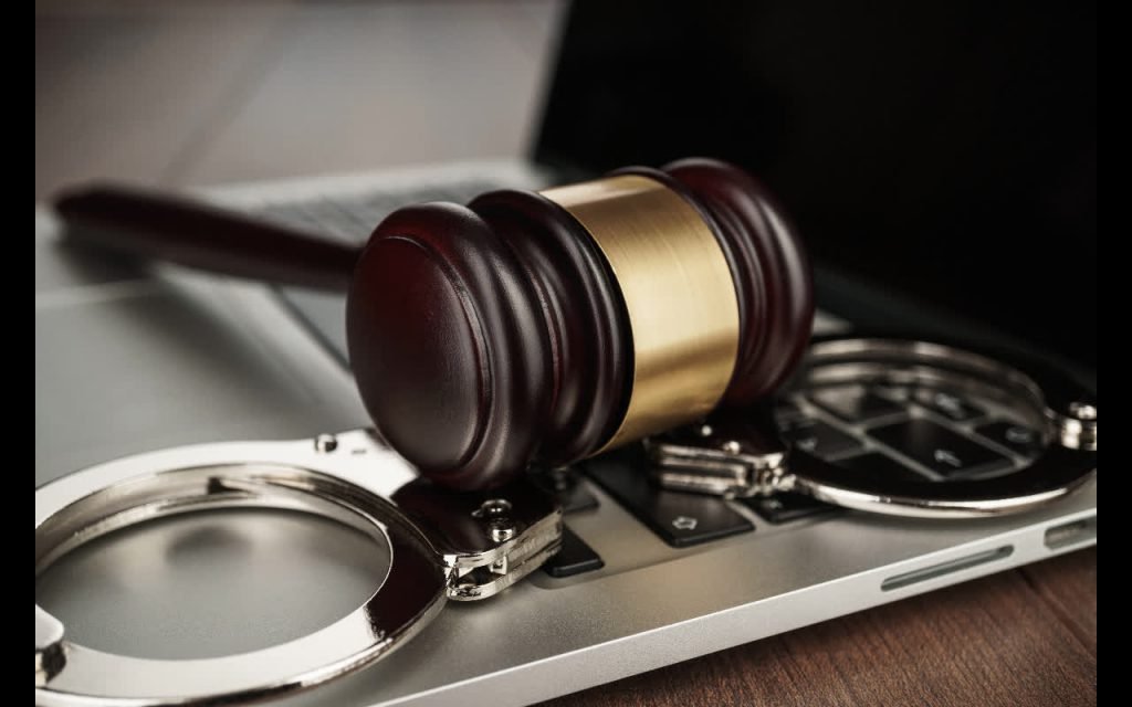 Handcuffs and a gavel on a laptop