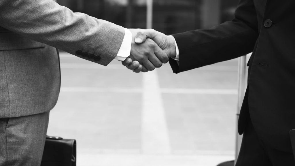 Two people shaking hands on a business deal