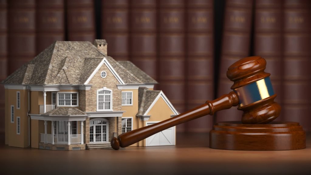 Model house with a gavel and law books
