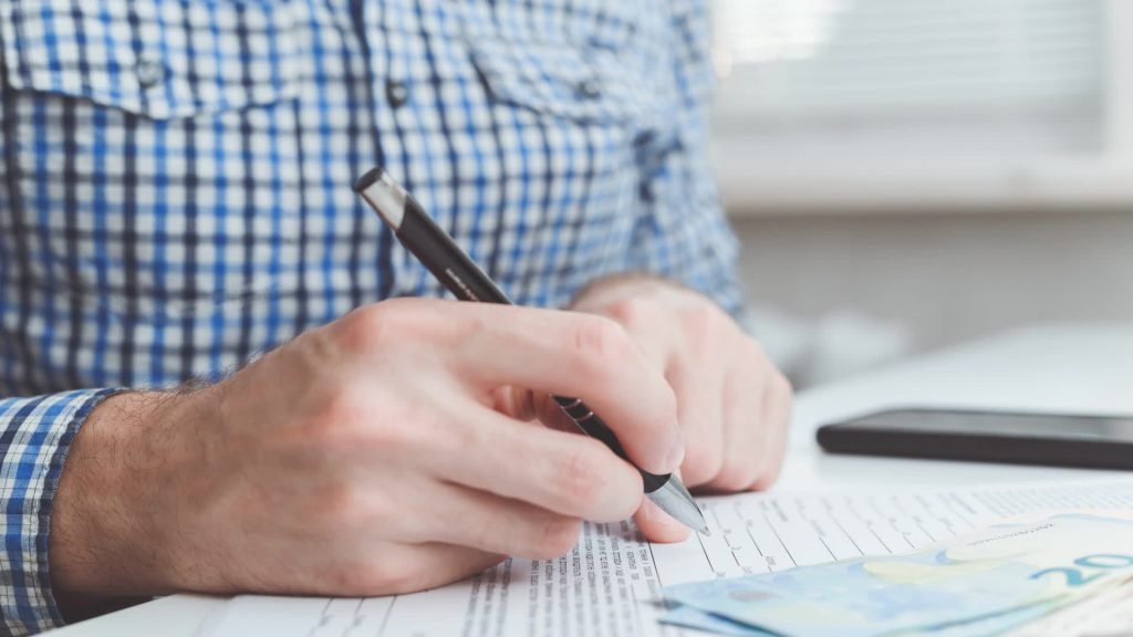 Man signing a document at his desk