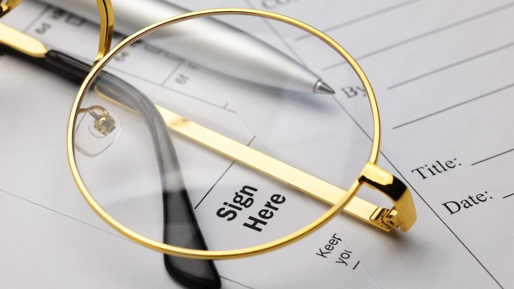 Document with a sign here tab and reading glasses