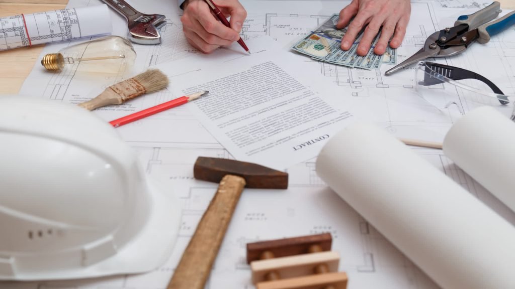 Building plans and a contract being signed